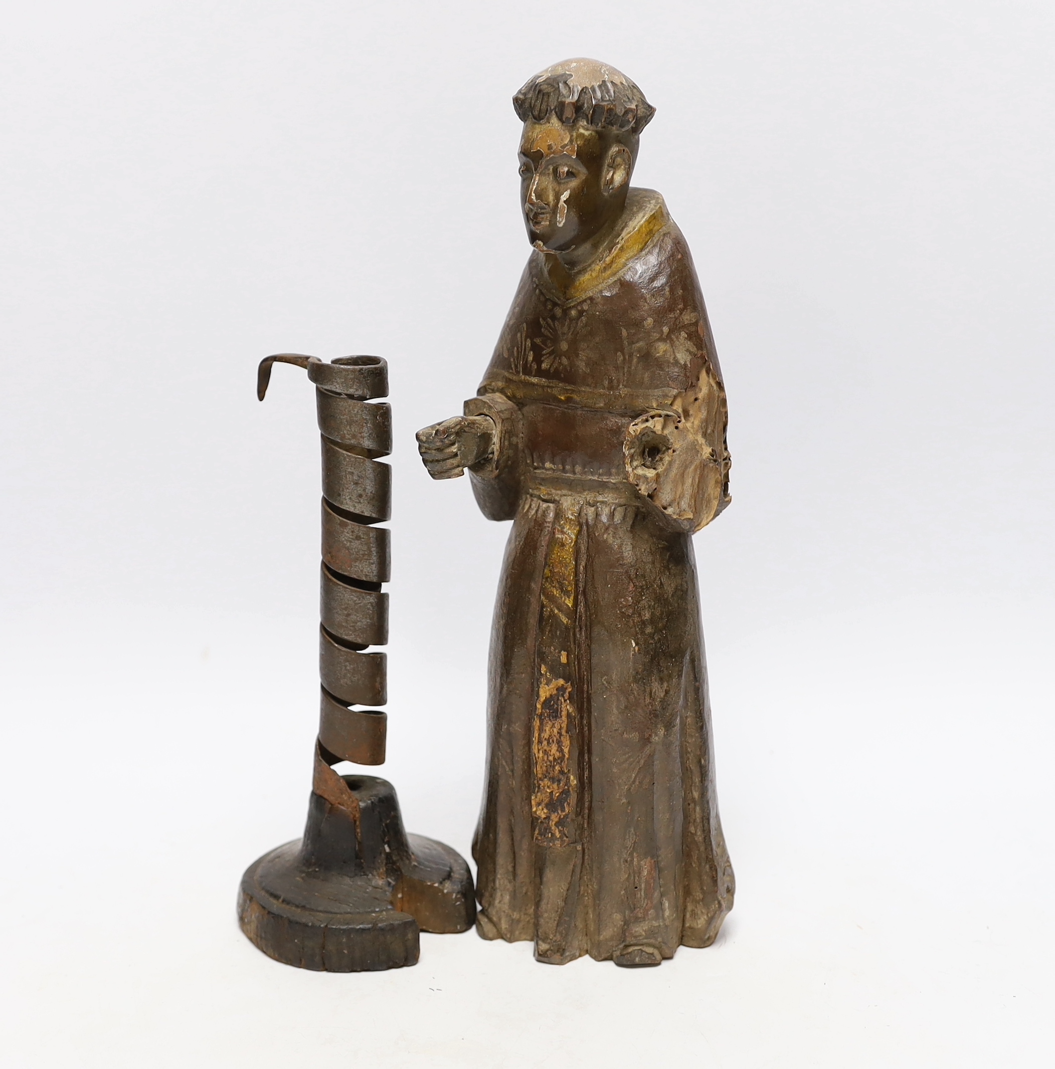 An 18th century Spanish carved and painted wood figure of a monk and 18th century ‘rat de cave’ candlestick, wooden knight 32cm high